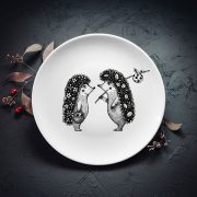 Balts vidējais šķīvis ar melnu divu ežu zīmejumu