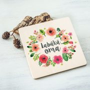 Balts krūžu paliktnis ar krāsainu tekstu: "Labākā oma"