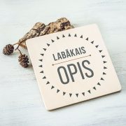 Balts krūžu paliktnis ar krāsainu tekstu: "Labākais opis"