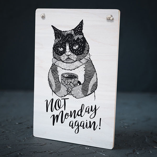 Balts dekoratīvais koka dēlītis ar melnu kaķa zīmējumu un tekstu: "Not Monday again!"