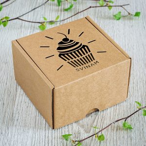 Kartona kaste ar lāzergravētu kesa zīmējumu un tekstu: "Svinam"