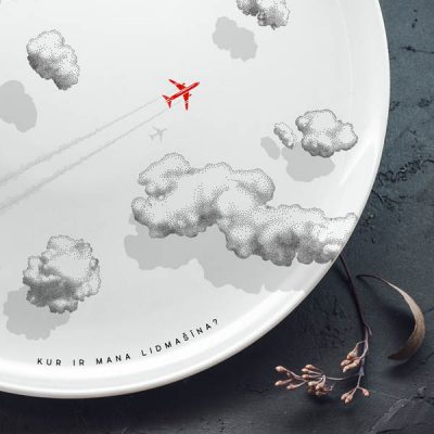 Lielais šķīvis ar melniem mākoņiem un sarkanas lidmašīnas zīmējumu un tekstu: "Kur ir mana lidmašīna?"