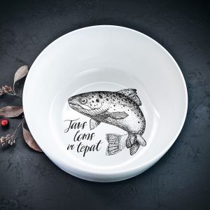 Balta lielā bļoda ar melnu zivs zīmējumu un tekstu: "Tavs loms ir tepat"