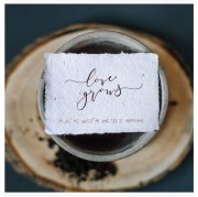 balta diedzējamā kartīte ar uzrakstu "Love grows"