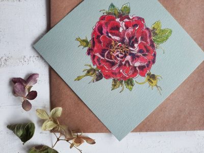 Apsveikuma kartīte ar rozā rozes ziedu uz zila fona, 10x10cm